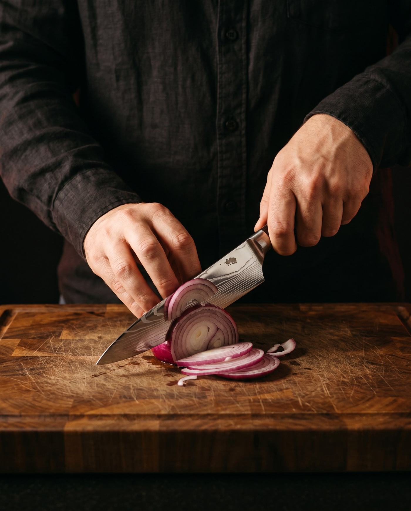 Een rode ui snijden met het Gyuto Koksmes op een houten snijplank